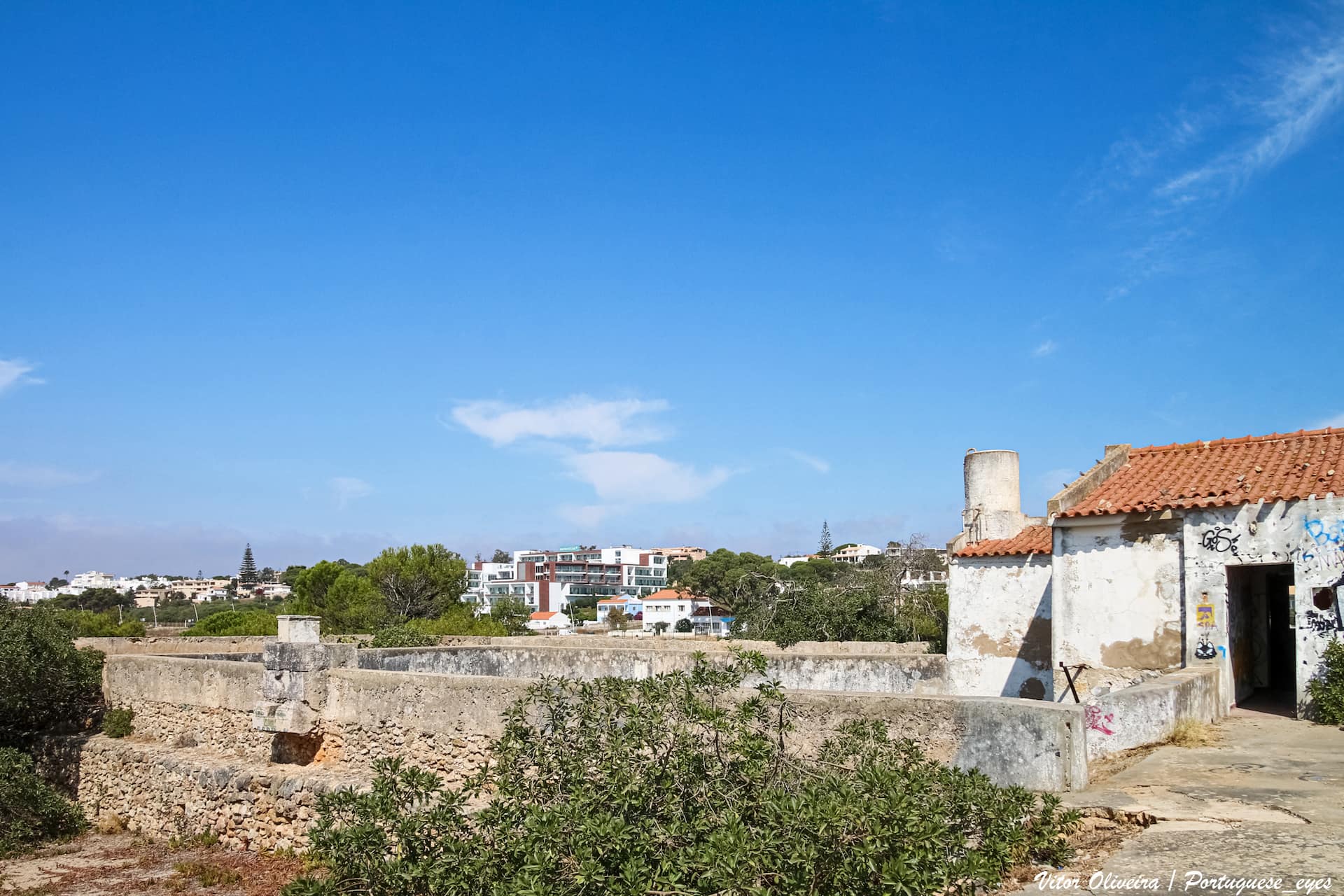O Forte da Meia Praia, originalmente conhecido como Forte de São Roque ou Forte da Meia Praya, é um monumento militar situado na zona da Meia Praia, no concelho de Lagos, em Portugal. Construído no Século XVII para defender a baía de Lagos, foi muito danificado no Sismo de 1755 e reconstruído nos finais desse século.[1] Posteriormente deixou de ter funções militares, tendo sido utilizado como um posto da Guarda Fiscal.[1] Fachada Sudeste do forte, em 2016. Descrição Localização e composição O forte está situado numa pequena colina[2] no areal da Meia Praia, da qual recebeu o nome pelo qual é popularmente conhecido.[1] Localiza-se na zona central da Baía de Lagos,[2] numa posição estratégica que permitia dominar aquele acidente geográfico, no lado oriental da cidade.[3] A Norte do monumento situa-se o Apeadeiro da Meia Praia, e a Leste existe um parque de estacionamento para os utentes da praia.[4] O edifício, de pequenas dimensões,[2] apresenta uma traça maneirista, tendo sido construído de acordo com as novas práticas de artilharia da altura.[5] Tem um formato semelhante ao do Forte da Ponta da Bandeira, mas mais básico e de menores dimensões, com uma planta simples e de forma sensivelmente quadrangular, composta por três arestas regulares, enquanto que a do lado Noroeste é irregular.[2] No lado do oeano possui uma bateria,[3] cujo acesso é feito através de uma rampa,[5] enquanto que no lado Noroeste apresenta dois meios baluartes, que ladeiam o portal de entrada.[3] Sobre este portal existia uma lápide comemorativa da sua construção ou reconstrução por Nuno da Cunha de Ataíde, sendo ainda visível em 1945 a inscrição: «GOVERNAmdo este REINO Nuno DA CVNHA DE / [ATHAIDE CON DE PONTEVE] [...] DE cerra DE / [...] ESTE FOR / [...] [MEIA] PRIA e e / [...] MÃO AQUI F.».[4] No interior do forte sobreviveu apenas uma dependência com dois pisos, que é mais elevada do que as muralhas, pelo que provavelmente não faria parte da organização original do edifício.[2] Com efeito, as várias campanhas de obras pelas quais passou o forte modificaram completamente a sua disposição interna, dificultando a compreensão de como seria a estrutura original.[2] Embora o forte tenha sido originalmente conhecido como de São Roque, o seu patrono é São José.[5] A sua denominação original refere-se à Praia de São Roque, que era o nome antigo da Meia Praia.[4] Conservação e importância O Forte da Meia Praia tem uma grande importância histórica como parte do conjunto de defesas marítimas do Algarve, tendo sido considerado pelo historiador José António Martins como um símbolo das fortificações marítimas da Praça de Guerra de Lagos e do património militar, espelhando «toda a grande construção que foi feita no século XVII, no reinado de D. Afonso VI», além de ser «um dos ex-libris de toda a zona nova da cidade de Lagos».[6] Foi classificado como Monumento de Interesse Público.[3] Fotografia do Forte da Meia Praia, publicada na obra Monografia de Lagos, de 1910. História Construção No Século XVII, esteve em curso um programa para a instalação de fortalezas ao longo de vários pontos estratégicos da costa Sul do Algarve, entre Sagres e Castro Marim, com a importante cidade de Lagos a possuir um sistema próprio.[2] O Forte da Meia Praia foi construído provavelmente na segunda metade do Século XVII, entre 1674 e 1675, por ordem do Governador das Armas do Algarve, D. Nuno da Cunha de Ataíde, Conde de Pontével, durante o reinado de D. Afonso VI, já sob a regência de D. Pedro.[4] Servia para defender a praia[4] e controlar a baía a oriente de Lagos, funcionando assim como um complemento à rede de defesas marítimas da cidade.[2] Com efeito, considerava-se que os canhões das outras fortalezas costeiras de Lagos não eram suficientemente fortes para cobrir a baía, criando uma perigosa lacuna na defesa da zona nascente de Lagos.[1] A fortificação serviria igualmente para guardar a foz da Ribeira da Carrapateira,[4] uma linha de água de pequenas dimensões, que posteriormente desapareceu devido ao progressivo assoreamento.[5] Planta do Forte da Meia Praia, elaborado na Década de 1790, que mostra as várias alterações que tinham sido recentemente feitas no interior. Séculos XVIII e XIX Em 1754, o forte foi inspeccionado pelo governador e capitão general, D. Rodrigo António de Noronha e Meneses, possuindo nessa altura duas peças de ferro e uma peça de bronze, ainda em funcionamento, e uma outra também em ferro, já avariada.[4] Foi muito danificado pelo Sismo de 1755 e consequente maremoto, tendo algumas paredes sido derrubadas.[2] Os efeitos do terramoto foram descritos num relatório de 18 de Julho de 1765, elaborado pelo sargento-mor, Romão José do Rego: «pelo impulso que fez o mar, depois do terramoto do ano de 55, arruinou-se em diferentes partes e lançou na areia, feita em pedaços, a quarta parte da sua extensão. Não tem, ao presente, quartel nem armazens para a pólvora e a sua re-edificação fará de despensa 600$000 réis».[4] O processo de reconstrução foi muito prolongado e falhou em devolver a importância de origem ao forte, tendo uma notícia de 1785 relatado que ainda não tinha sido reinstalado o quartel nem o armazém para pólvora.[2] Por volta de 1790, foi elaborada uma planta e descrição do forte por José de Sande Vasconcelos, onde referiu que tinha duas baterias, uma a nascente que estava incapaz, e outra a Sul, uma ermida no centro do pátio, e um quartel e armazém, ambos no meio baluarte do lado poente.[4] As obras de reconstrução definitivas só foram iniciadas em 1796, devido à iminente ameaça da invasão pelas forças francesas.[4] Estes trabalhos incluíram a reconstrução do terrapleno da bateria em Setembro desse ano, tendo as peças sido entretanto colocadas na areia da praia.[4] Segundo um documento relacionado com o pagamento aos trabalhadores, as obras decorreram pelo menos até Junho de 1797.[4] Um alvará de 1805 do príncipe regente, D. João, ordenou que o forte ficasse dependente da praça-forte de Lagos.[4] Em 1821, existe um relato que a fortificação ainda se encontrava em bom estado, possuindo três peças em ferro.[4] Porém, logo no ano seguinte existe um ofício do capitão engenheiro, José Feliciano Farinha, que descreveu o forte como abandonado e destruído.[4] O forte foi considerado como um importante elemento do sistema de defesa costeira durante a Guerra Civil Portuguesa,[3] mas perdeu as suas funções militares após o final daquele conflito, em 1834, pelo que foi desguarnecido e desartilhado.[3] Em 1840, foi inspeccionado pelo major de engenharia Francisco António Garcez, que confirmou que não tinha guarnição nem peças de artilharia.[4] Num artigo publicado no jornal O Panorama de 5 de Novembro de 1842, é relatado que as fortalezas da Meia Praia e da Ponta da Bandeira já não eram capazes de defender eficazmente a baía, por não terem a guarnição e artilharia adequadas.[7] Em 1849 foi estudado por dois oficiais do Corpo de Engenheiros, que relataram que o forte precisava de grandes obras, incluindo a desobstrucção parcial das muralhas e reparações no reboco.[4] Em 11 de Julho de 1873, o imóvel foi entregue à Câmara Municipal de Lagos, que o cedeu de forma gratuita à Alfândega de Faro.[4] Em 1878 foi instalado um posto de fiscalização, estando nessa altura de volta à posse da autarquia.[4] Embora esta função tenha levado a grandes alterações nos seus interiores, incluindo o restauro e ampliação dos compartimentos, terá sido provavelmente devido à presença do posto da Guarda Fiscal que o imóvel tenha permanecido inteiro até ao Século XXI.[1] Em 1881, foi elaborada uma nova planta do forte, assinada por Henrique dos Santos Rosa.[4] Forte da Meia Praia em 2007. Séculos XX e XXI Durante o Século XX, foram feitas várias tentativas falhadas para preservar e rentabilizar o imóvel, tendo a Direcção-Geral dos Edifícios e Monumentos Nacionais chegado a avançar com uma proposta para a instalação de uma unidade turística.[2] Em 1944 o posto foi trespassado à Guarda Fiscal, ficando guarnecido por um segundo cabo e quatro soldados, possuindo nessa altura um valor patrimonial de 5.500$00 Escudos.[4] Em 1945 ainda existem registos da lápide sobre o portal, embora já muito incompleta.[4] Em 1962 foram feitas obras no posto da Guarda Fiscal, que incluíram a substituição da cobertura, o reboco e a caiação das paredes, tanto no interior como no exterior, a instalação da rede telefónica e de iluminação eléctrica, construção de sanitários no antigo adarve e de uma fossa séptica no lado poente do forte, aplicação de uma bomba manual no poço, e instalação de uma porta de madeira e de uma vedação em arame na parte em ruínas dos paramentos no lado Sul.[4] Posteriormente esta intervenção foi concluída com a construção de um passadiço de blocos de cimento no lado Norte do imóvel, e a instalação de água canalizada e de uma bomba eléctrica no poço.[4] Um ofício de 1972 da Direcção-Geral dos Edifícios e Monumentos Nacionais informou que seriam necessários 400 mil Escudos para fazer as obras de consolidação mínimas que o forte necessitava, pelo que a sua recuperação não era considerava viável, a não ser que fosse financiada por um subsídio especial.[4] Em 1982 o posto da Guarda Fiscal deixou de estar guarnecido, passando a ser utilizado apenas como casa de férias dos serviços sociais daquele órgão.[4] As instalações da Guarda Fiscal deixaram de funcionar em meados da Década de 1990,[3] mas só em 25 de Janeiro de 2000 é que foi elaborado o auto de entrega do imóvel à Fazenda Pública, encerrando definitivamente o posto.[4] O processo para a classificação do forte iniciou-se em 12 de Outubro de 1956, com a Junta Nacional da Educação a propôr a sua classificação como Imóvel de Interesse Público.[2] Porém, só classificado como Monumento de Interesse Público pela Portaria n.º 41/2014, de 7 de Janeiro, mas este diploma foi revogado pela Portaria 116/2015, de 21 de Janeiro, devido a várias imprecisões no preâmbulo.[2] Com efeito, o documento descreveu erradamente o imóvel como tendo dois torreões, referência que causou alguma polémica a nível local e regional.[8] O forte voltou a ser classificado pela Portaria n.º 182/2015, de 24 de Fevereiro,[3] que corrigiu a descrição para dois meios baluartes, e expandiu o resumo histórico do monumento.[8] Em 2004 a Assembleia Municipal de Lagos pediu ao governo para que o antigo forte passasse para a sua tutela, pedido que no entanto foi recusado.[6] Em Setembro de 2007, foi feita uma segunda tentativa por parte da Assembleia Municipal e da autarquia, que pediram ao Ministério da Defesa para transferir a posse do forte, de forma a proceder à sua recuperação e adaptação para outros usos.[9] Foram avançadas várias possíveis utilizações para aquele espaço, incluindo como centro de actividades ligadas ao ambiente, uma colónia de férias, um observatório astronómico, um núcleo museológico dedicado ao oceano, ou um centro para observação e conservação de espécies marinhas.[9] Este pedido foi feito devido ao avançado estado de abandono e degradação do monumento, e à inexistência de planos para a sua recuperação por parte do Ministério da Defesa.[9] Porém, este segundo pedido também foi negado.[6] Com efeito, na Década de 2000 os muros apresentavam grandes fendas, estando em risco de desmoronamento caso não fossem feitas obras de reparação.[1] Em 2014, a vereadora com o pelouro da cultura na Câmara de Lagos, Maria Fernanda Afonso, afirmou à Agência Lusa que ainda estavam a trabalhar na recuperação e reutilização do antigo forte, e que não tinha sido encontrada quaisquer documentação sobre a transferência para a alfândega, no Século XIX.[6] Nessa altura, a autarquia estava a planear a instalação de um centro ambiental ou de um núcleo museológico ligado ao mar, baseado principalmente no papel histórico do forte.[6] Em 2016, o governo lançou o programa Revive, que tinha como finalidade entregar vinte monumentos, incluindo o Forte da Meia Praia, à gestão privada, no sentido de proceder ao seu restauro e adaptação a utilizações culturais e comerciais, como hotéis, restaurantes ou museus.[10] Nos princípios de 2020, o governo manifestou a intenção de abrir quatro concursos para a utilização turística de património público, que incluiu o Forte da Meia Praia.[11] Em Maio de 2021 a Coligação Democrática Unitária denunciou o avançado estado de degradação em que se encontrava o imóvel, tendo exigido a realização de obras urgentes de forma a prevenir o seu desaparecimento. <a href=" https://pt.wikipedia.org/wiki/Forte_da_Meia_Praia " rel="noreferrer nofollow">pt.wikipedia.org/wiki/Forte_da_Meia_Praia</a>