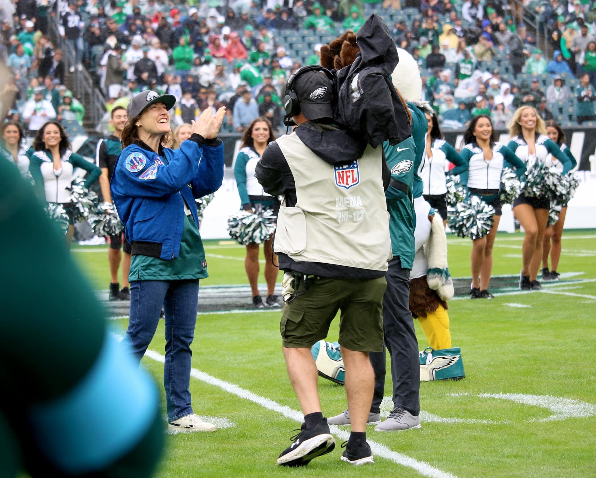 NASA astronaut and mission specialist of the agency's Artemis II mission, Christina Koch, lead the fans in singing the Eagles Fight Song from the field at an NFL game between the Philadelphia Eagles and the Los Angeles Rams at Lincoln Financial Field on Sunday, Oct. 4, 2026, in Philadelphia. NASA’s engagement at NFL games is part of the agency's Inspiration Tour, aimed at strengthening connections between NASA and its partners and showcasing innovation in air and space in the lead up to the MAX POWER aerospace technology expo and airshow at the agency's Kennedy Space Center in early November. Photo Credit: (NASA/Thalia Patrinos)
