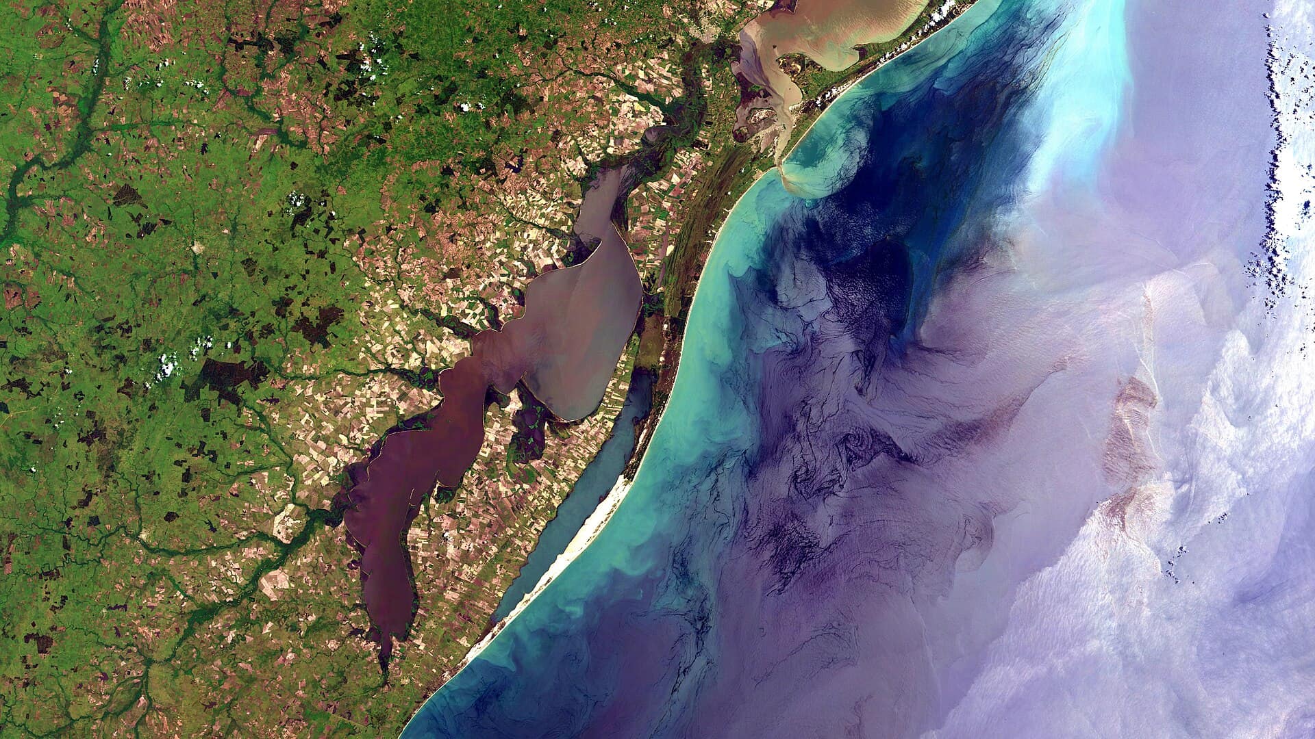 Costa do Rio Grande do Sul de Rio Grande a Santa Vitória do Palmar. Em terra: Padrão quadriculado de amarelo a verde passando por marrom são lotes agrícolas, principalmente arroz irrigado nas terras baixas. Em branco areia das praias. Em marrom e verde, com listras pretas onde alagado, restinga. A Lagoa Mirim está do lado esq. da imagem, em cor cinza arroxeado a esverdeado e preto. No Mar: Áreas próximas a costa com sedimentos e maior atividade biológica em azul claro. Águas profundas em azul escuro ou cinza arroxeado, com sunglint. Na parte de cima da imagem é notável a pluma de sedimentos saindo da Lagoa dos Patos em marrom / Rio Grande do Sul coast from Rio Grande to Santa Vitória do Palmar. At land: Checkred pattern from yellow to brown and green are agriculture plots, mostly lowland irrigated rice. Beaches sand appears in white. In brown and green, with black stripes where flooded, Atlantic coast restingas. Mirim lake is at image left side, in greenish and purpleish grey and black. At sea: In light blue, near the coast, areas with sediments and biological activity. Deep water in dark blue or purpleish gray with sunglint. Notable at image top is Patos lagoon sediments plume, in brown. riograndeRS #santavitoriadopalmar #lagoamirim #lagoamangueira #banhadodotaim #santaizabeldosul #riograndedosul #sunglint #taim #arroz #rice #restinga #irrigatedrice #arrozirrigado #sensoriamentoremoto #remotesensing #cbers4 #cbers #inpe #geotecnologias Imagem / Image CBERS4 AWFI Costa do / Coast of Rio Grande do Sul. Coordenadas do centro da imagem / Image center: 32°36'36.9"S 52°14'32.3"W Data / Date: 29-11-2019 / 2019-11-29 RGB151413 (cor verdadeira / true color) Cena / Scene: 159 / 135 Autor / Author: Oton Barros (DSR/OBT/INPE) Imagem em HD / HD Image Visite-nos em www.dsr.inpe.br