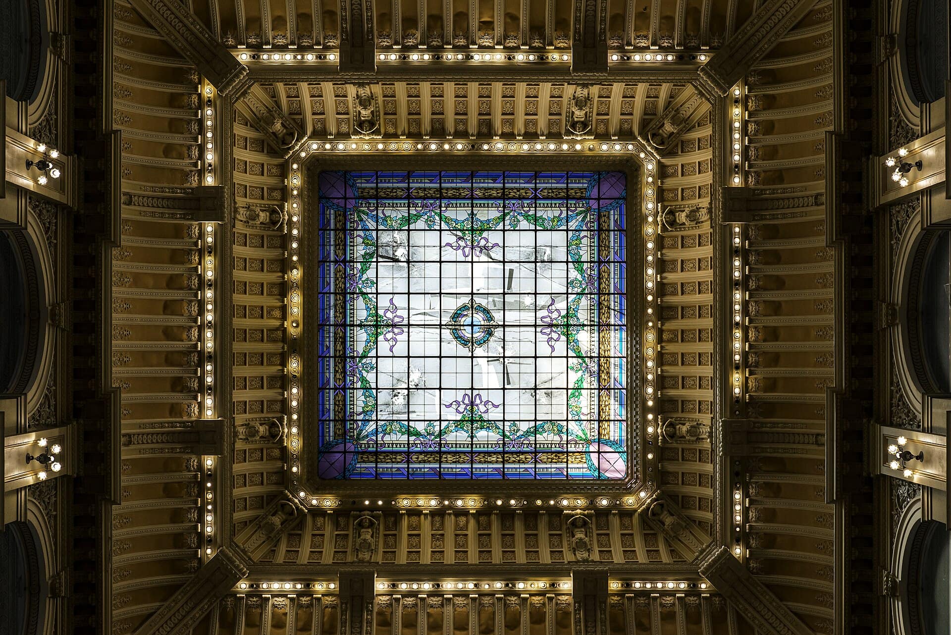 Stained glass ceiling of the National Library of Brazil . Located in Rio de Janeiro , the capital city of Brazil from 1822 to 1960, more specifically at Cinelândia square, it is the depository of the country's bibliographic and documentary heritage.