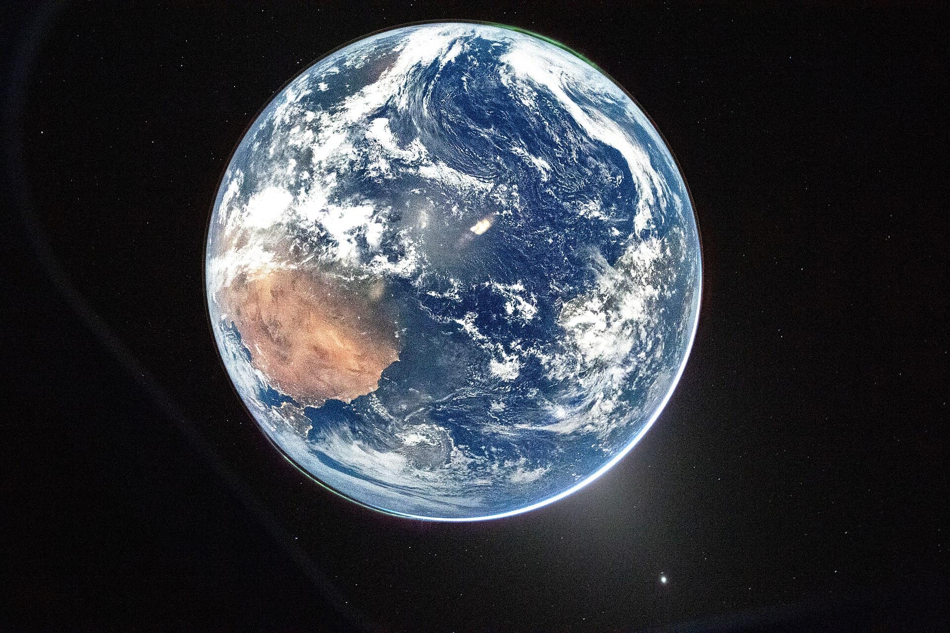 A view of Earth taken by NASA astronaut and Artemis II Commander Reid Wiseman from one of the Orion spacecraft's window after completing the translunar injection burn on April 2, 2026. The image features two auroras (top right and bottom left) and zodiacal light (bottom right) is visible as the Earth eclipses the Sun. Venus is shown on the bottom right of the image. Contrast has been brightened using GIMP.