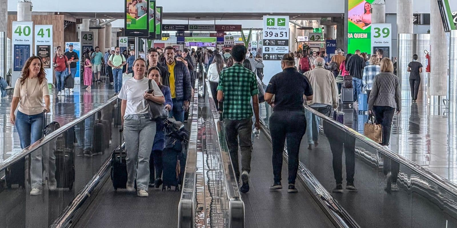 Brasília (DF), 17/03/2026 – Movimentação de passageiros no Aeroporto de Brasília durante operações de embarque e desembarque. Pessoas circulam pelos terminais com bagagens enquanto aviões realizam pousos e decolagens, refletindo o fluxo intenso de viagens na capital federal. Foto: Rafa Neddermeyer/A